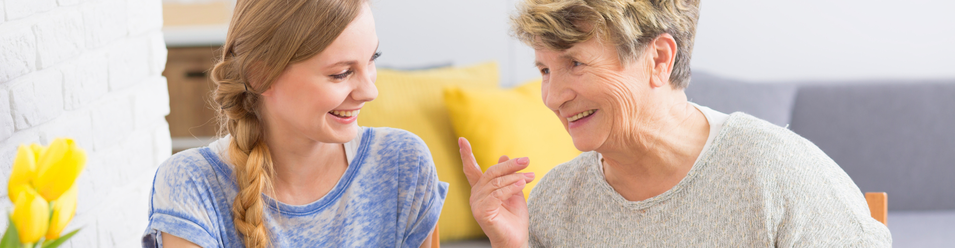 Smiling younger woman and older woman sharing tea.